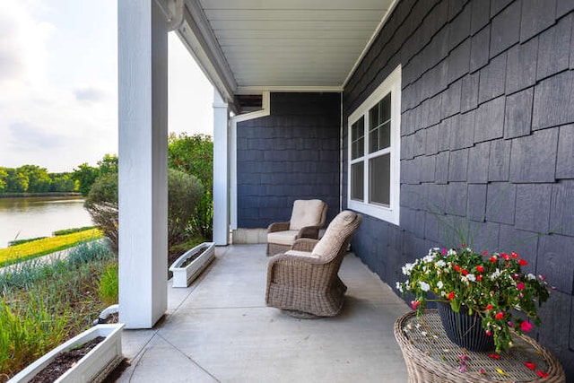 view of patio / terrace featuring a water view and a porch