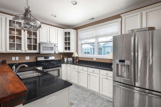 kitchen featuring white cabinetry, appliances with stainless steel finishes, crown molding, and sink