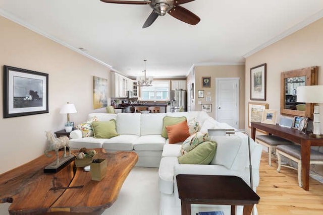 living room featuring crown molding, ceiling fan with notable chandelier, and light wood-type flooring