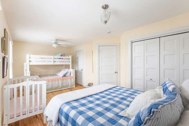 bedroom with ceiling fan, wood-type flooring, and a closet