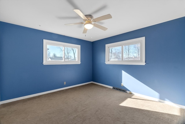 spare room with ceiling fan, a healthy amount of sunlight, and carpet floors