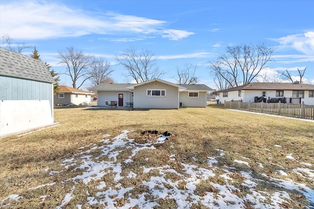 snow covered rear of property with a lawn