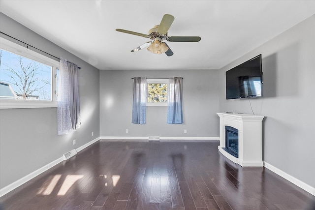 unfurnished living room with dark hardwood / wood-style floors and ceiling fan