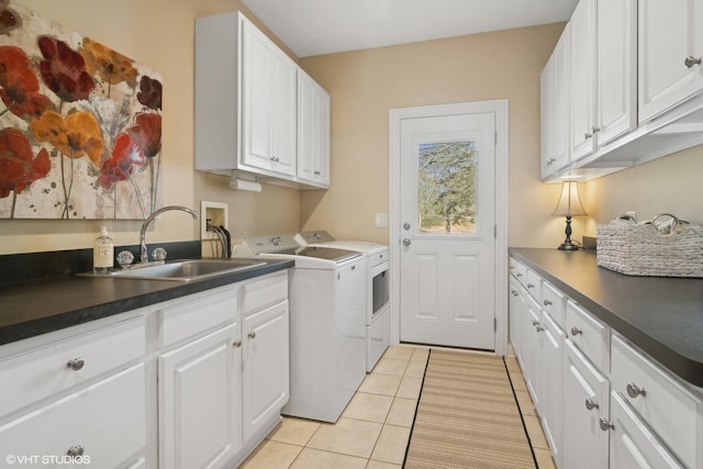 laundry area featuring a sink, light tile patterned floors, washing machine and clothes dryer, and cabinet space