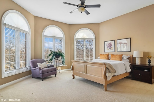 bedroom featuring a ceiling fan, light carpet, and baseboards