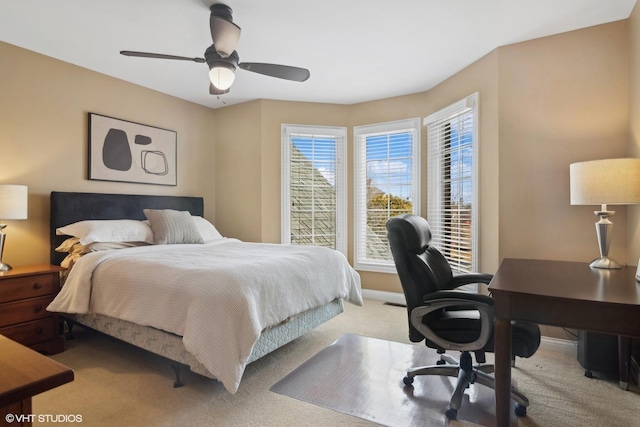 carpeted bedroom with ceiling fan and baseboards