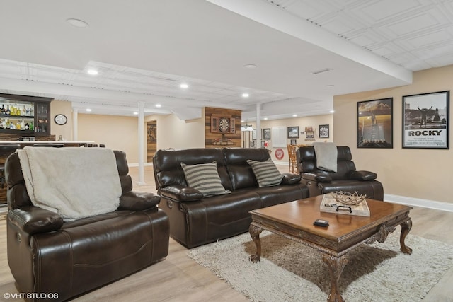 living area with a bar, recessed lighting, light wood-style floors, and baseboards