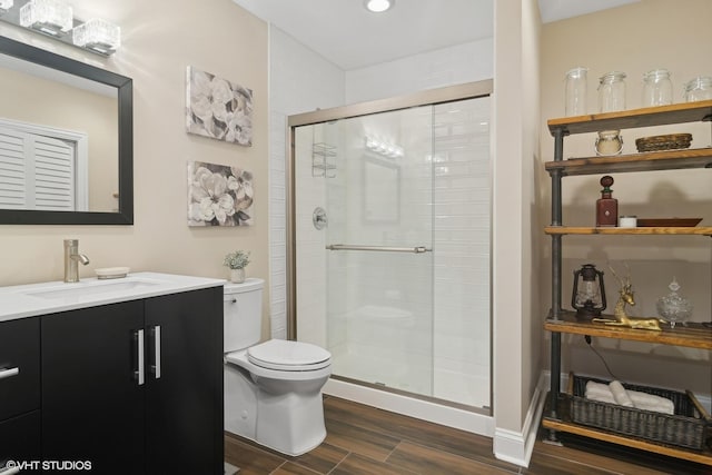 full bath with vanity, a shower stall, toilet, and wood finished floors