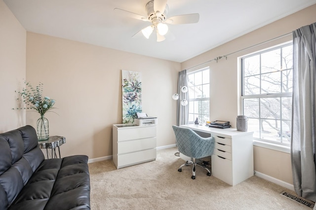 carpeted home office featuring ceiling fan