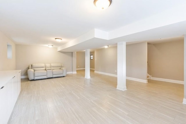 living area featuring baseboards and light wood finished floors