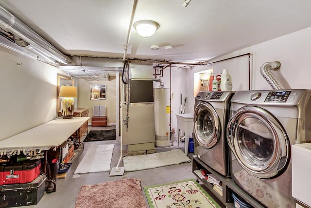 clothes washing area featuring laundry area, washing machine and clothes dryer, and gas water heater