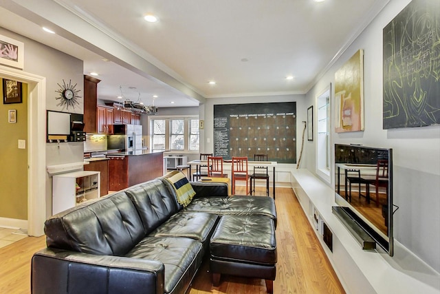 living area with recessed lighting, light wood-style flooring, and ornamental molding