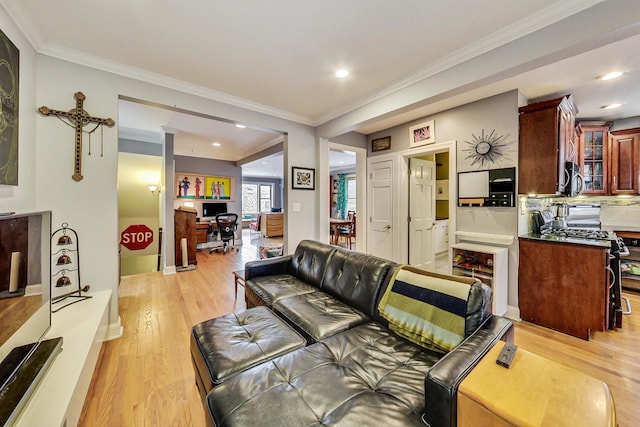 living area featuring ornamental molding, light wood finished floors, and recessed lighting