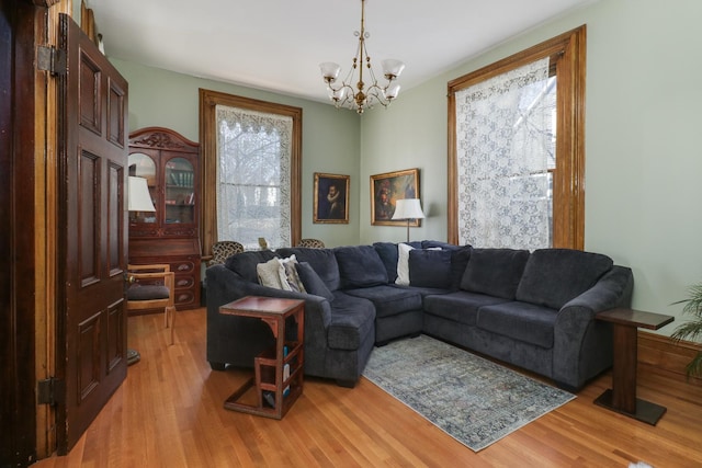 living room with a chandelier and light wood-type flooring