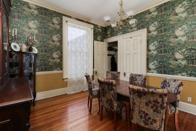 dining area featuring crown molding, wood-type flooring, and a chandelier