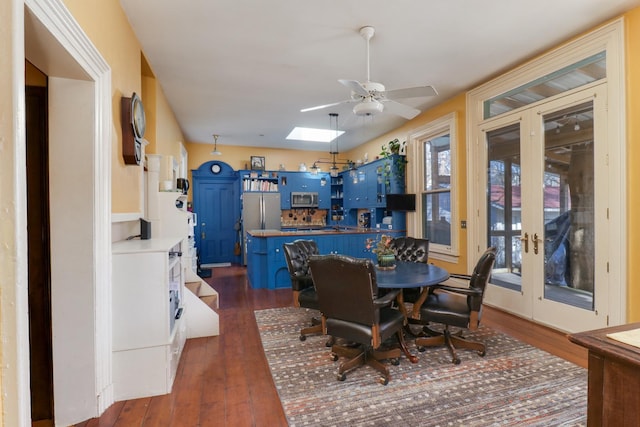 dining area featuring french doors, ceiling fan, dark hardwood / wood-style flooring, and a skylight