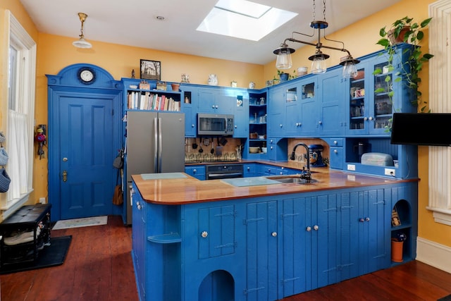 kitchen featuring blue cabinets, appliances with stainless steel finishes, pendant lighting, and kitchen peninsula