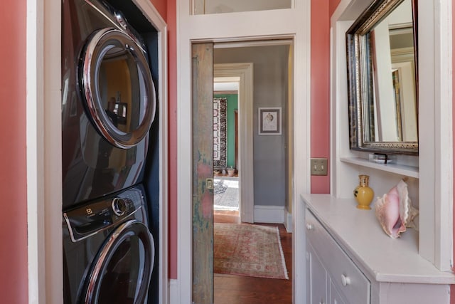 laundry area with stacked washer and clothes dryer and wood-type flooring