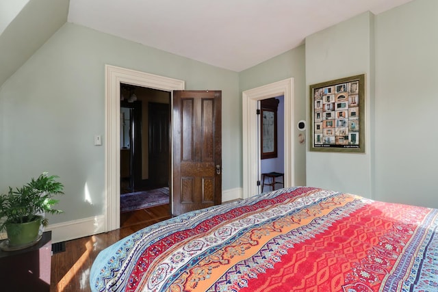 bedroom with lofted ceiling and dark wood-type flooring