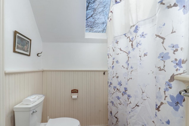 bathroom featuring toilet, curtained shower, and vaulted ceiling