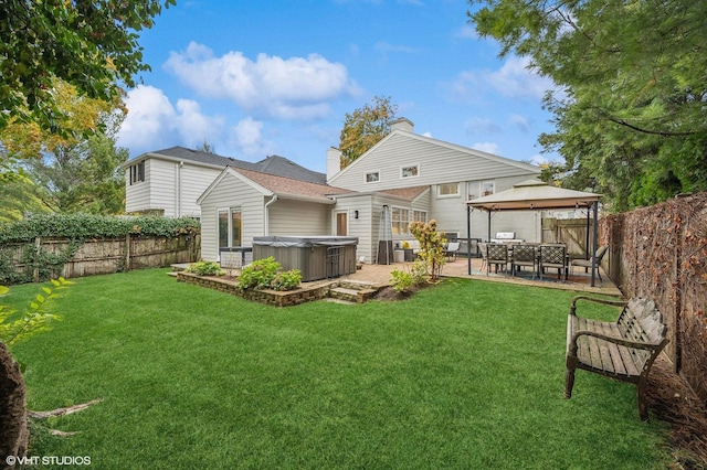 back of house with a yard, a gazebo, a hot tub, and a patio