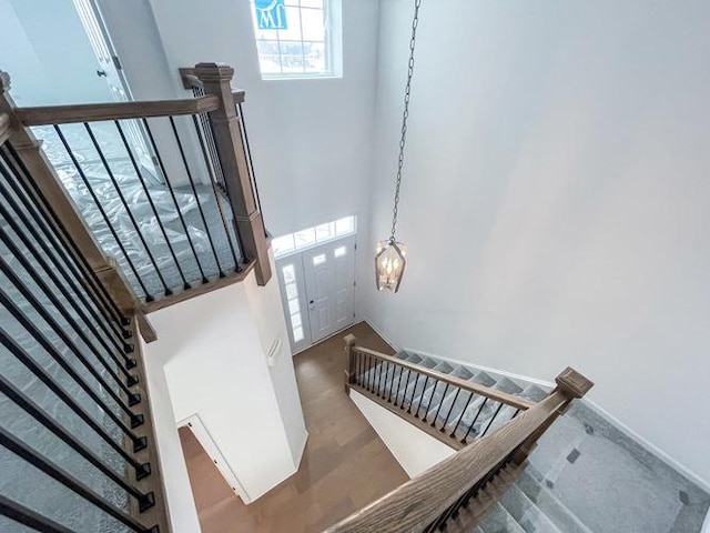 stairway with hardwood / wood-style flooring and a high ceiling