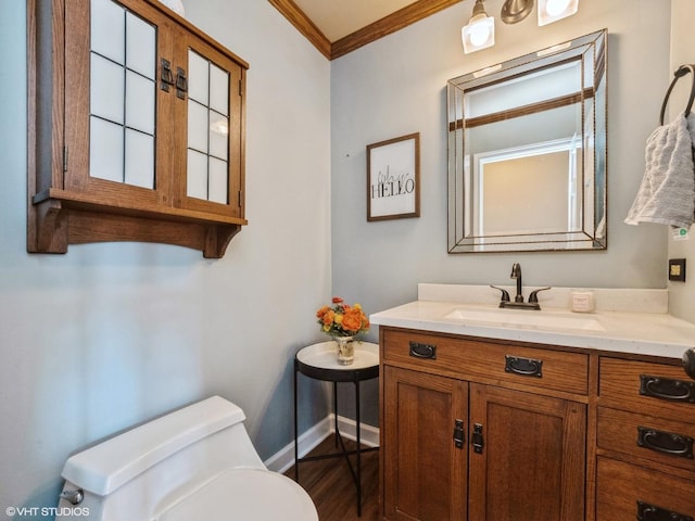 bathroom with vanity, ornamental molding, and toilet