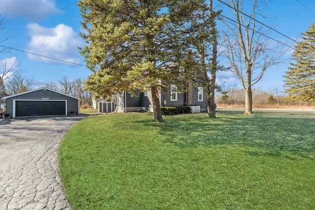 view of front of home with a garage, central air condition unit, a front yard, and an outdoor structure