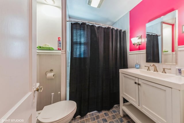 full bath with a shower with shower curtain, wainscoting, vanity, and toilet