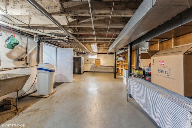 basement featuring a sink and freestanding refrigerator