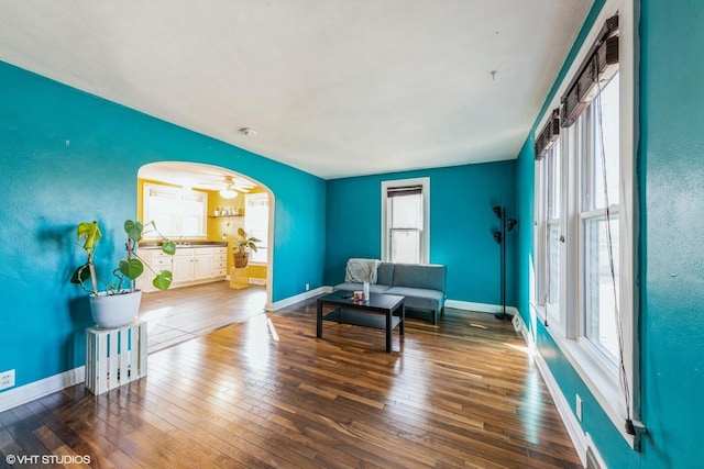 sitting room featuring arched walkways, visible vents, hardwood / wood-style flooring, and baseboards