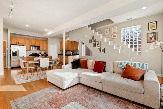 living room with rail lighting and light hardwood / wood-style flooring