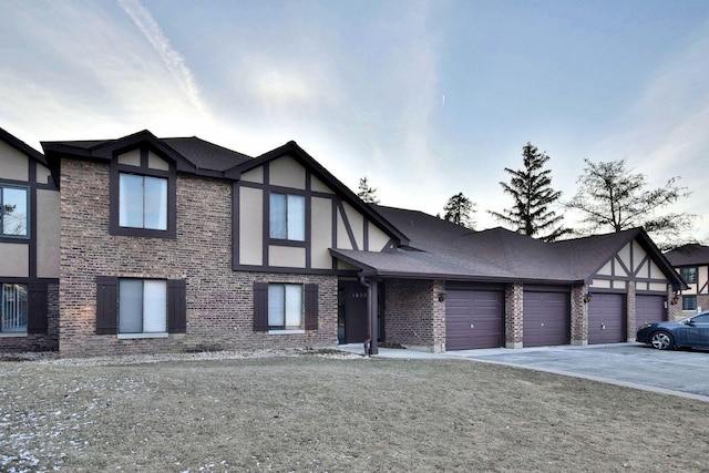 tudor home featuring a front lawn and a garage