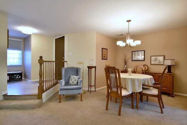 dining room with a chandelier and light colored carpet