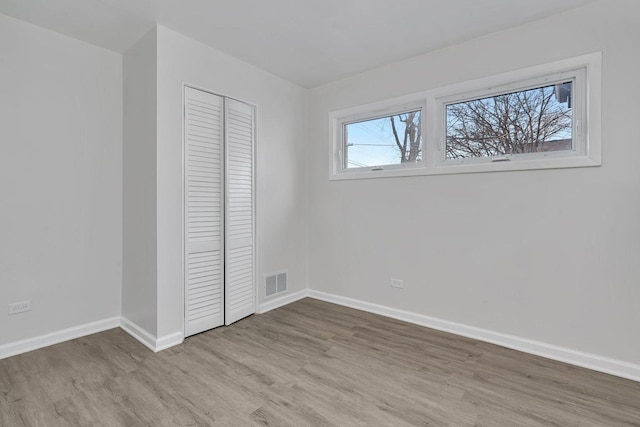 unfurnished bedroom with a closet and light hardwood / wood-style flooring