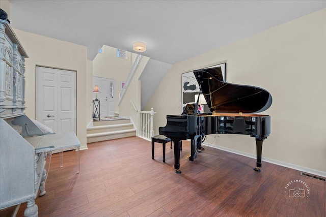 sitting room with stairway, wood finished floors, and visible vents