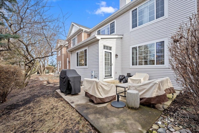 back of house featuring a patio area and a chimney