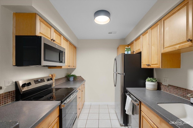 kitchen with stainless steel appliances, sink, light brown cabinets, and light tile patterned floors