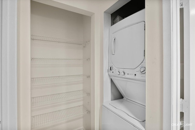 clothes washing area with stacked washer / dryer