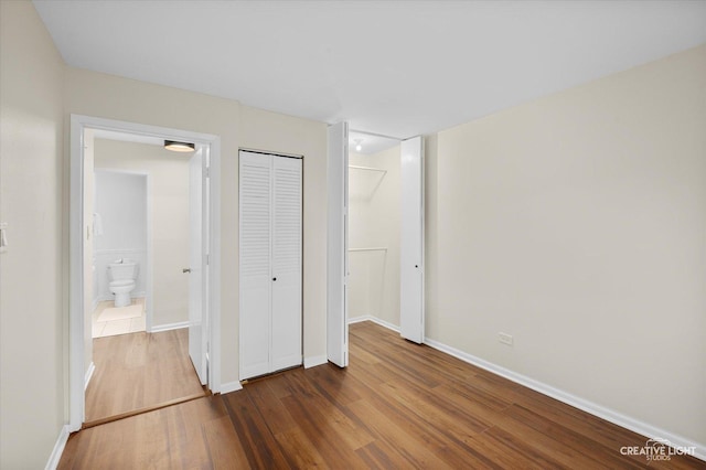 unfurnished bedroom featuring dark hardwood / wood-style floors and a closet