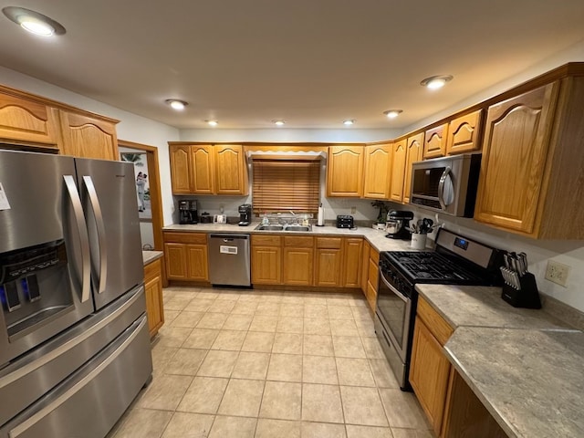 kitchen with sink, light tile patterned floors, and appliances with stainless steel finishes