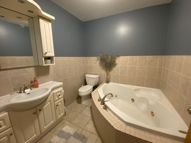 bathroom featuring tile walls, vanity, a relaxing tiled tub, toilet, and tile patterned floors