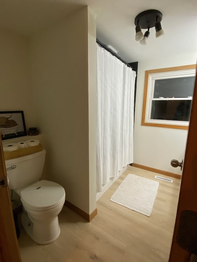 bathroom with hardwood / wood-style flooring and toilet