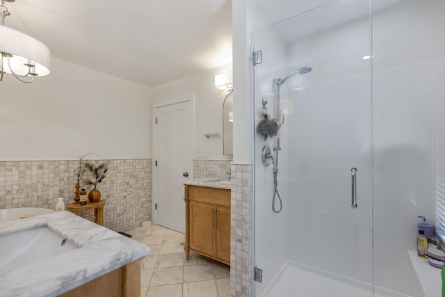 bathroom featuring vanity, tile walls, and walk in shower