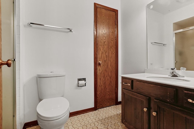 bathroom with vanity, a shower with shower door, and toilet