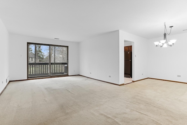 carpeted spare room with a chandelier