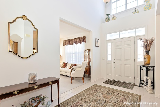 tiled foyer featuring a towering ceiling