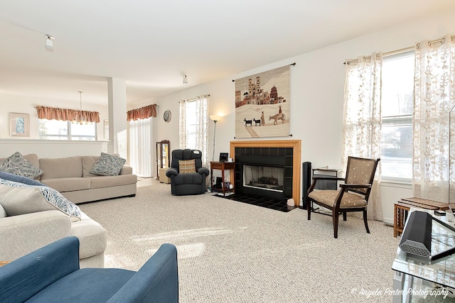 living room featuring a tiled fireplace and carpet