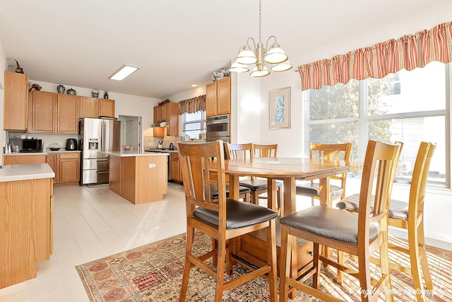 dining space with light tile patterned flooring and a notable chandelier