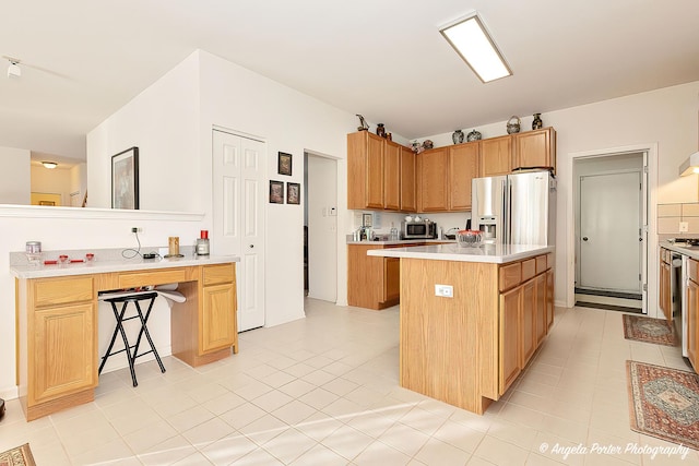 kitchen with a kitchen bar, appliances with stainless steel finishes, and a kitchen island